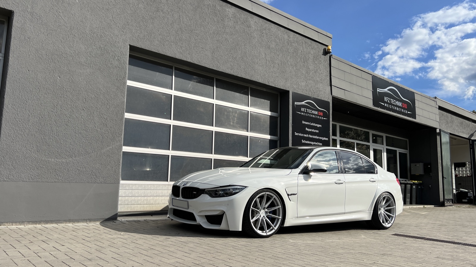 BMW M3 vor dem Werkstatt-Tor der Kfz Technik Dib